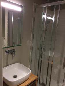 y baño con lavabo y ducha. en Hôtel Azur, en Cap d'Agde