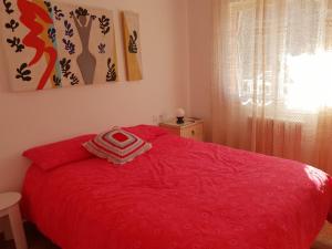 1 dormitorio con cama roja y manta roja en Ca la Rita en Castellfollit de la Roca