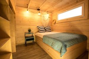 ein Schlafzimmer mit einem Bett in einer Holzhütte in der Unterkunft Domki U Huberta Międzywodzie in Międzywodzie