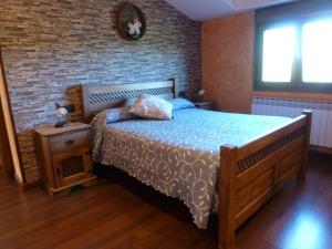 um quarto com uma cama e uma parede de tijolos em Casa Rural & SPA Mirador Sierra de Béjar em Guijo de Ávila