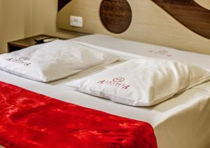 Duas almofadas brancas em cima de uma cama em Alkimia Hotel em Campo Grande