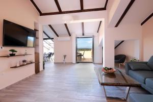 a living room with a couch and a tv at Apartments Galboka in Nerezine