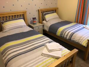 Duas camas sentadas uma ao lado da outra num quarto em 41 Larchwood Drive Holiday Home em Inverness