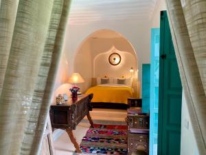 a bedroom with a bed and a table in a room at Riad 11 Zitoune in Marrakech