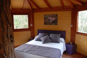 a bedroom with a bed in a wooden cabin at Cabanes Dosrius in Canyamás
