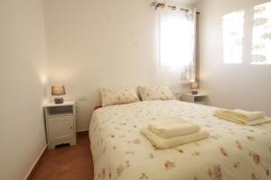 a bedroom with a bed with two towels on it at Hadass Desert Inn in Dimona