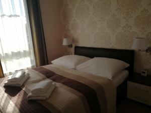 ein Schlafzimmer mit einem Bett mit zwei Handtüchern darauf in der Unterkunft Apartament Mariva B03 z ogródkiem - Pobierowo - blisko morza - przy kompleksie Grand Laola SPA in Pobierowo