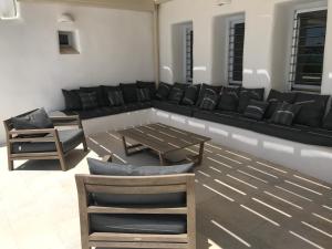 een woonkamer met een zwarte bank en stoelen bij The Sand Collection Villas in Santa Maria