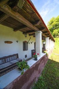 a porch of a house with a bench and flowers at Vén Diófa Kúria in Balaton