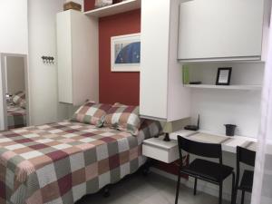 Habitación pequeña con cama y escritorio. en Cosy studio in Copacabana, en Río de Janeiro