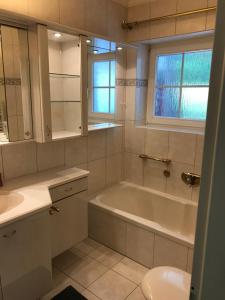 a bathroom with a tub and a sink and a toilet at Strandbungalow / Ferienhaus Ostsee in Scharbeutz