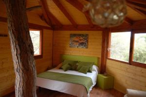 1 dormitorio con 1 cama en una cabaña de madera en Cabanes Dosrius en Canyamás