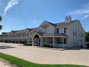 Country Inn & Suites by Radisson, Tulsa, OK في تولسا: مبنى ابيض كبير عليه لافته