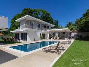 a villa with a swimming pool in front of a house at Uvita Paradise in Uvita