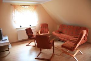 a living room with orange chairs and a couch at U pani Ani Żeglarska 18 in Augustów