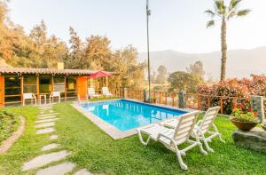 a villa with a swimming pool and a house at Decameron El Pueblo in Lima