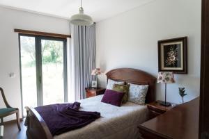 um quarto com uma cama com um cobertor em Casa Guarda Rios - São Pedro do Sul em São Pedro do Sul