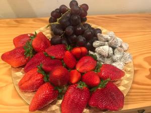 a plate of strawberries and grapes on a wooden table at c/ Ermita s/n Aceuchal Badajoz in Aceuchal
