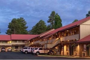 a building with cars parked in a parking lot at Branding Iron Motel in Chama