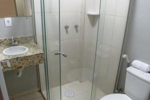 a bathroom with a shower and a toilet and a sink at Hotel Central in Lins