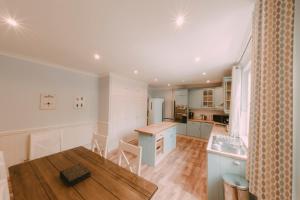 une cuisine avec des placards blancs et une table en bois dans l'établissement Owners Residence, à Wales