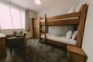 een slaapkamer met 2 stapelbedden en een stoel bij Owners Residence in Wales