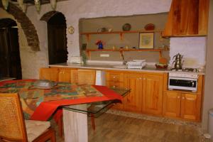 a kitchen with wooden cabinets and a table with at Eski Doganbey Houses in Doğanbey