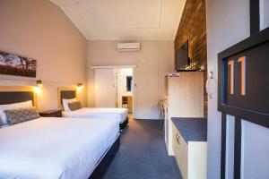 a hotel room with a bed and a television at Downs Motel in Toowoomba