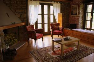 a living room with two chairs and a table at Eski Doganbey Houses in Doğanbey