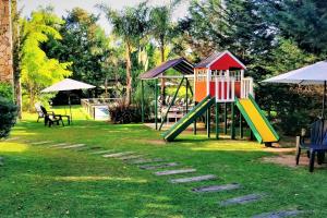 - une aire de jeux avec toboggan dans la pelouse dans l'établissement Terra Magna, à Mar de las Pampas