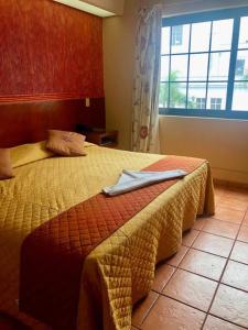 a hotel room with a bed with a towel on it at Hotel Virreynal in Córdoba