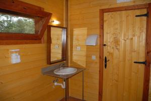 a bathroom with a sink in a wooden cabin at Cabanes Dosrius in Canyamás