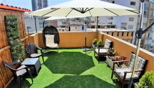 a patio with grass and an umbrella on a balcony at Pretty House Hotel in Lima