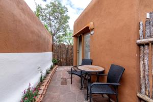 un patio con sillas, una mesa y una valla en Santa Fe Motel & Inn en Santa Fe