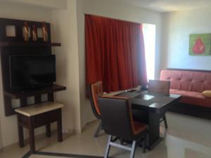 Hotel Bogavante في بارا دي نافيداد: غرفة معيشة مع طاولة طعام وأريكة