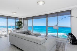 a living room with a couch and views of the ocean at Golden Sands on the Beach - Absolute Beachfront Apartments in Gold Coast