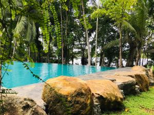Paaruwa Nature Resort في بيلياندالا: تجمع المياه الزرقاء مع الصخور والاشجار