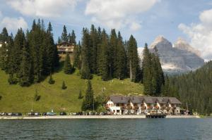 un rifugio sulla riva di un lago con una montagna di Quinz - Locanda Al Lago a Misurina
