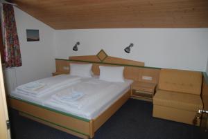 1 cama y 1 silla en una habitación pequeña en Haus Saumspitz, en Sankt Anton am Arlberg