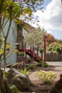 een huis met een rode trap in een tuin bij Smoke Lake Hot Springs Lodge & Camp in Rotorua +13 foto's