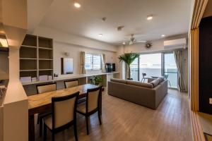 北谷町的住宿－MINATO Chatan Seaside Condominium，厨房以及带桌子和沙发的客厅。