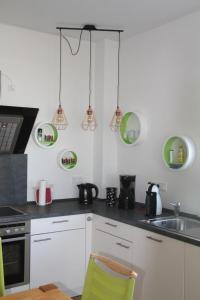 a kitchen with white cabinets and green plates on the wall at Zum großen Zernsee am Hafen in Kolonie Roeske