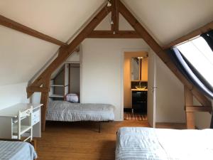 a attic bedroom with two beds and a window at Maison a la campagne in Cléty