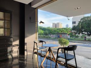 a table and two chairs in front of a window at Talmud Hotel Taichung in Taichung