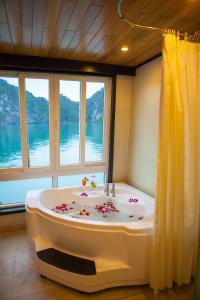 a bath tub in a room with a large window at Dragon Legend Cruise in Ha Long