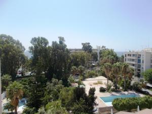 uma vista para um parque com árvores e uma piscina em Chrysanthos Boutique Apartments em Limassol