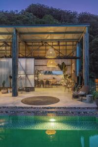 a pavilion with a pool in front of a house at Blackbird Luxury Accommodation in Mullumbimby