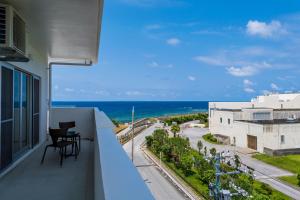 a balcony with a view of the ocean at MINATO Chatan Seaside Condominium in Chatan