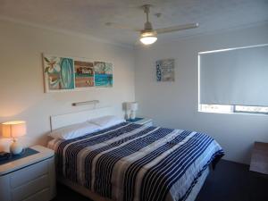 a bedroom with a bed and a ceiling fan at Tranquil Shores in Caloundra