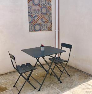 una mesa y dos sillas junto a una pared en Casa Magadè B&B, en Manduria